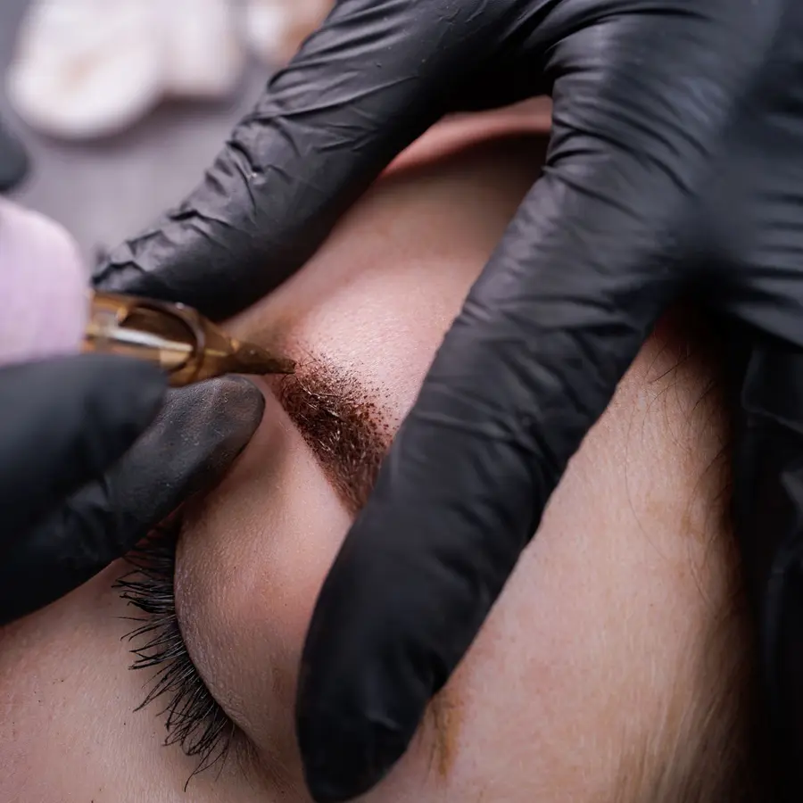 Microblading hair strokes being drawn on a brow